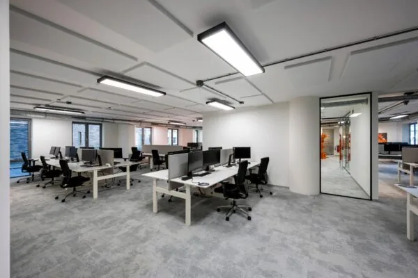 Moderne, open kantooruimte aan de Harry Banninkstraat met meerdere werkplekken, bureaustoelen en computerschermen.